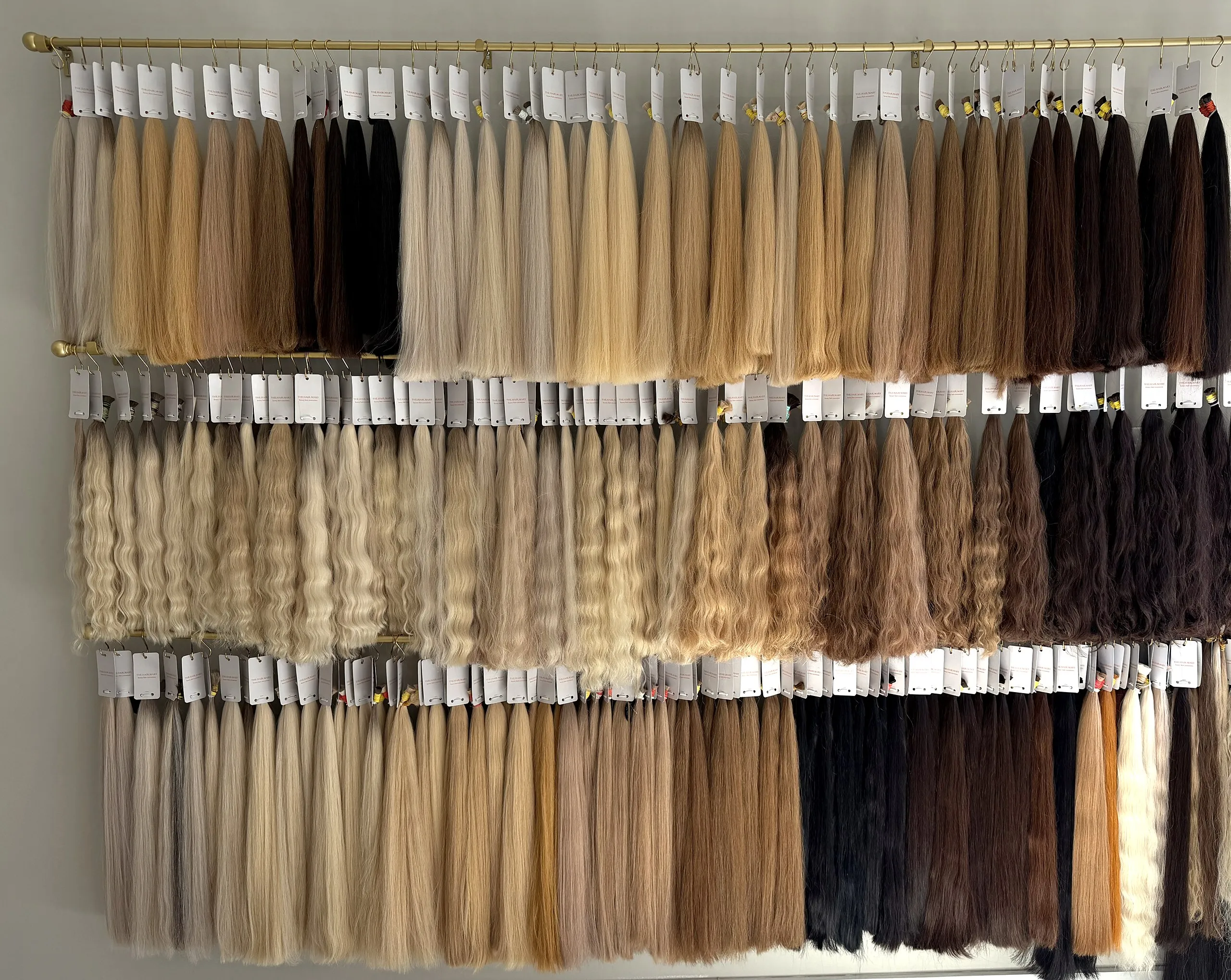 Our wall of Slavic hair bundles — straight and wavy, from platinum blonde to jet black