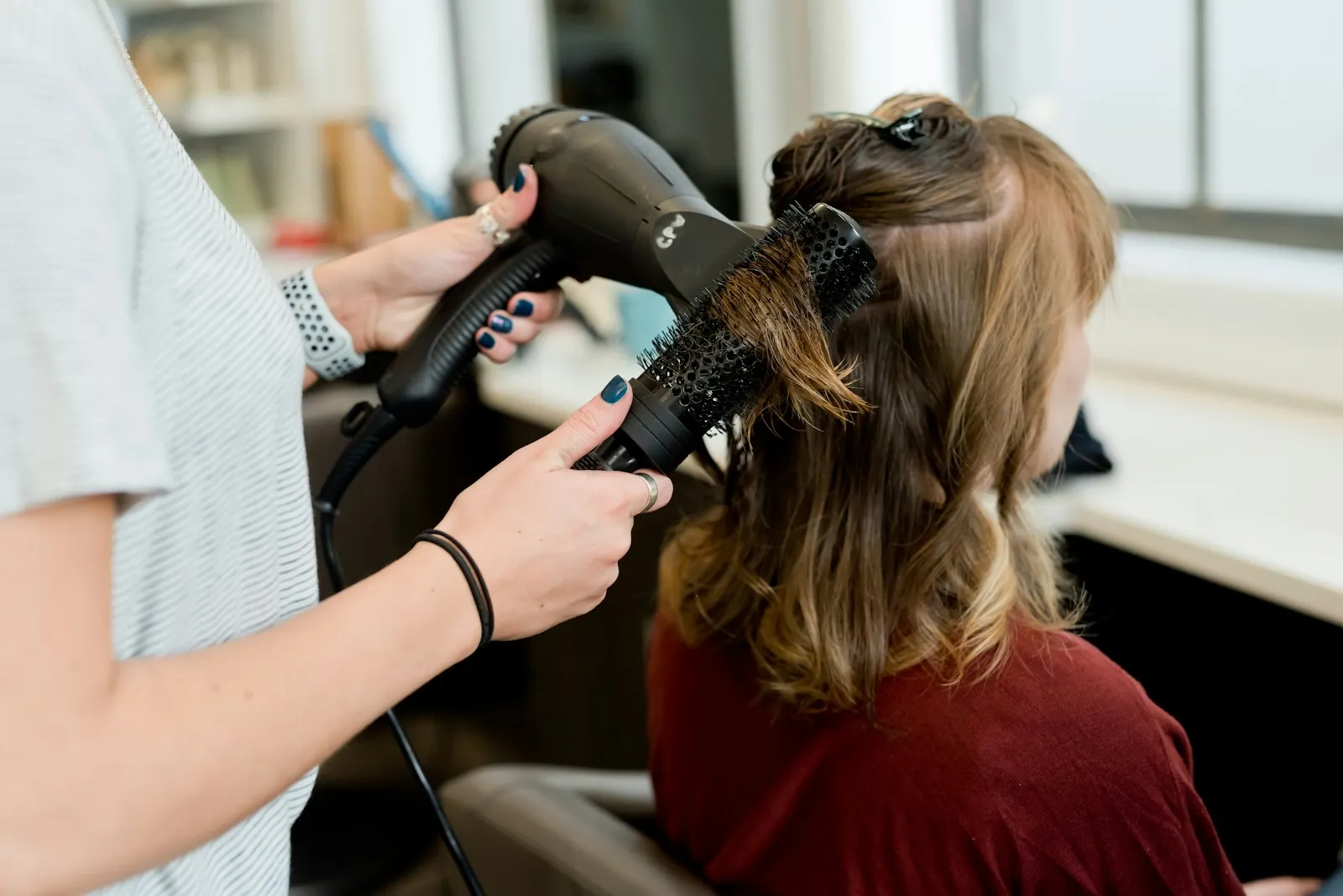 A stylist finishing a client's hair
